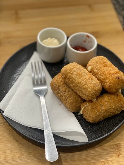 A plate of macaroni cheese croquettes with two dipping sauces