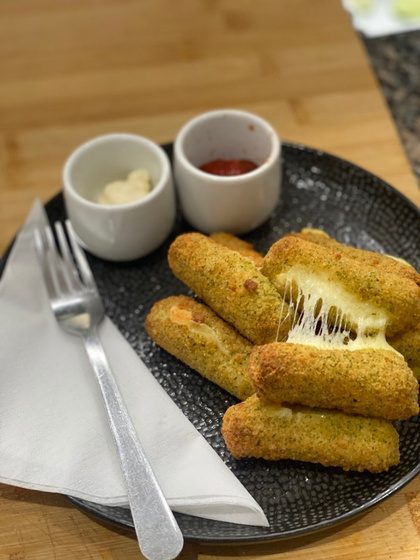 A plate of mozzarella sticks with two dipping sauces